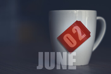 june 2nd. Day 2 of month,Tea Cup with date on label from tea bag. summer month, day of the year concept