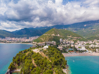 Beautiful view from sea to Budva coast and resort town of Becici on background of mountains, Montenegro. Drone aerial photo