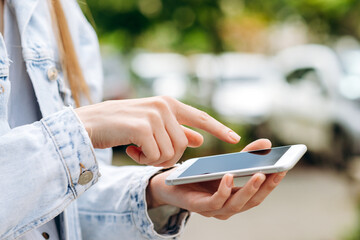 Modern smartphone holding female hands and touching screen.
