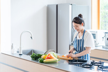 キッチンで料理する若い女性