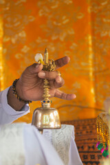 close up of the hand of a  balinese priest giving a blessing during a ceremony