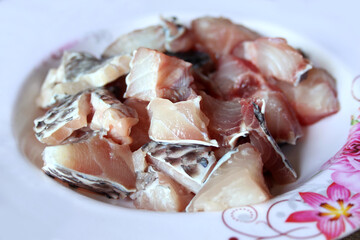 Tilapia fillet in plastic container close up isolated on white background