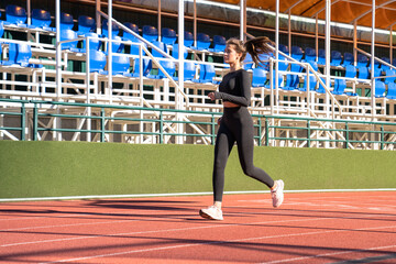 Athlete young fitness woman runner in black sportswear jogging exercise on a treadmill rubber...