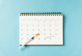 Syringe and calendar.  Vaccinations, medicines, vaccines, flu injections, illnesses, antibiotics,...