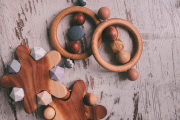 Cute wooden baby toys on the wooden background. Stars, planet toy. Eco accessories, beanbag and teethers for newborn. Flat lay, top view