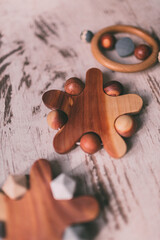 Cute wooden baby toys on the wooden background. Stars, planet toy. Eco accessories, beanbag and teethers for newborn. Flat lay, top view