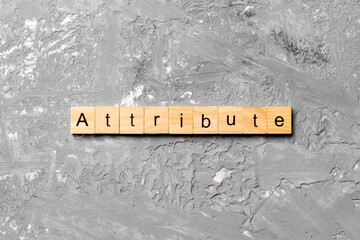 ATTRIBUTE word written on wood block. ATTRIBUTE text on cement table for your desing, concept