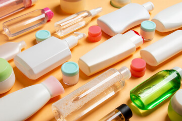 Close-up set of diffrent sized bottles and jars for cosmetic products on colored backgound. Face and body care concept with copy space