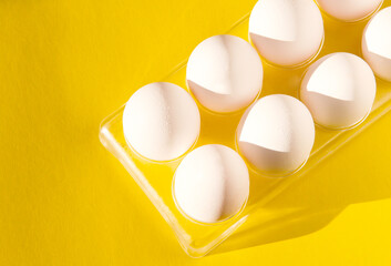 Tray with eggs on a yellow background. Eggs on a bright background.