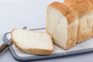 Well sliced loaf of bread on a cutting board with knife.