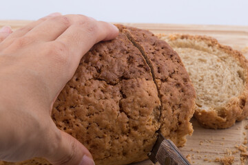 Well sliced loaf of bread on a cutting board with knife.