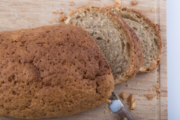 Well sliced loaf of bread on a cutting board with knife.