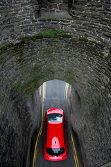 Bright red car going under bridge