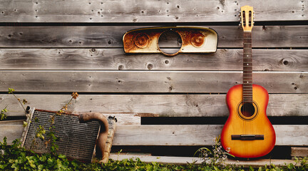 Acoustic guitar leaning against weathered boards