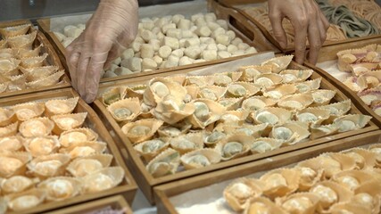 Tortellini on wooden trays at the italian restaurant kitchen, handmade italian food cooked. Lots of different tortellini prepared for restaurant meals