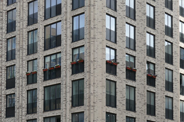 Fototapeta na wymiar Exterior of a high-rise multi-story apartment building - facade, windows and balconies.