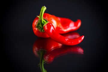 two hot spicy cayenne peppers on black background