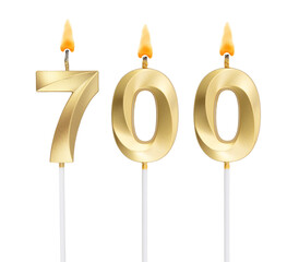 Golden birthday candle isolated on white background, number 700	