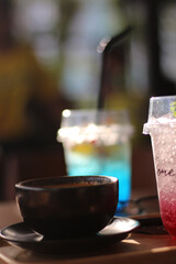 A glass of Italian soda and a cup of Cappucino on the wooden table