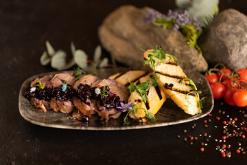 Beef roll with berry jam and grilled ciabatta, decorated with fresh flowers and sprouts of young peas. The main course is beef.