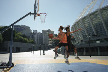 Obraz premium Image of african american guys playing basketball on city sports ground