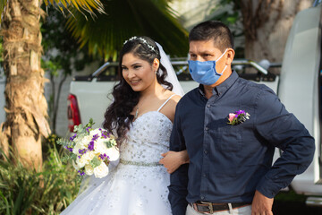 Padre con mascarilla entregando a su hija en su boda en tiempos de la pandemia del coronavirus