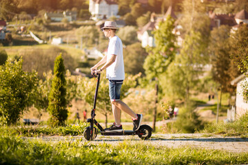 Young man riding electric scooter in park with amazing view