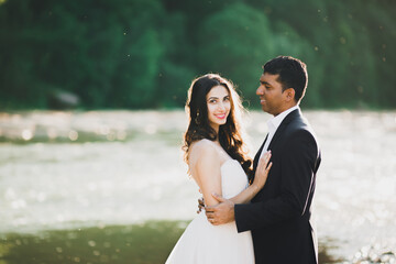 Wedding couple, groom and bride hugging, outdoor near river