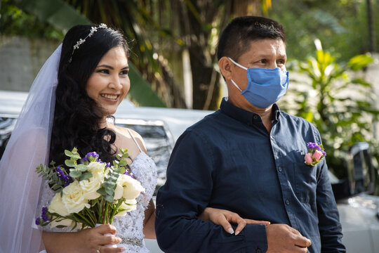 Padre con mascarilla entregando a su hija en su boda en tiempos de la pandemia del coronavirus