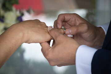 El novio poniendo el anillo a su esposa en su boda