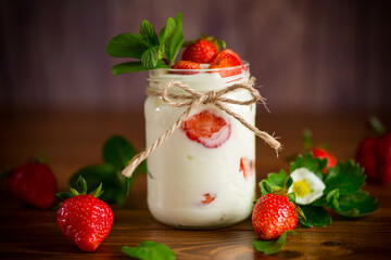 sweet homemade yogurt with ripe fresh strawberries in a jar