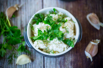 salted homemade cottage cheese with garlic and herbs in a bowl