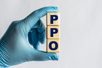 PPO is an acronym on cubes held by a hand in a blue glove