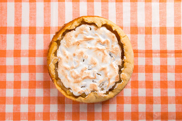 Pear pie with cream, homemade pastries on the table with a orange napkin. Copy space.