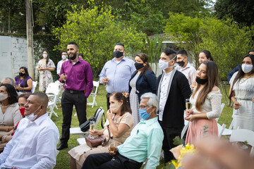 Personas disfrutando de una boda durante la pandemia del coronavirus, llevando puesta la mascarilla