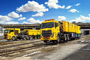 Fototapeta na wymiar The Modern Yellow rails maintaining machine car stand by for making maintainance the rail with blue sky.