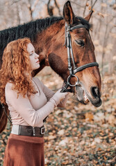 Woman with horse posing outdoors on autumn background