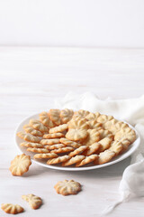 Group of Butter Cookies, on a white plate, on a white wooden table.