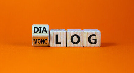 Fliped a cube and changed the German word 'monolog' - 'monologue' in English to 'dialog' - 'dialogue' in English. Beautiful orange background. Business concept. Copy space.