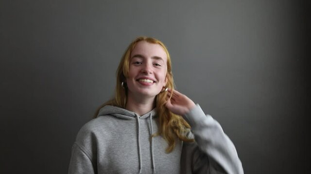 junge Frau macht einen Kopfball mit Fu&szlig;ball w&auml;hrend eines Portraits im Studio