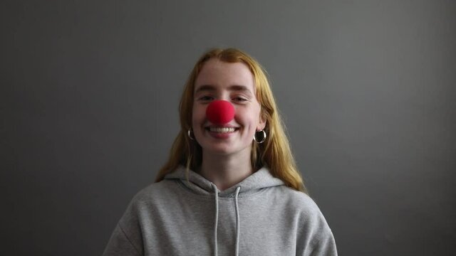 junge Frau mit roter Naseschaut in die Kamera