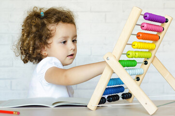 preschooler child learning to count. girl playing with mathematical abacus. kid and math....