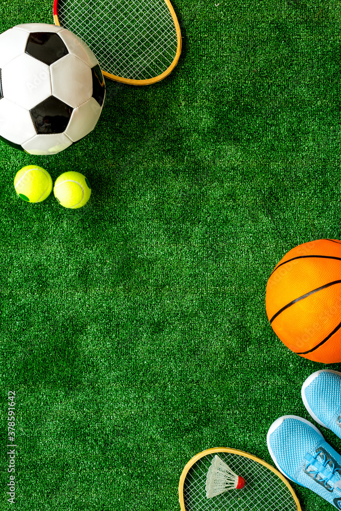 Sticker Flat lay of sport balls - football, basketball on grass top view copy space