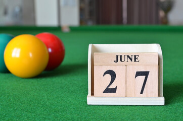 June 27, number cube with balls on snooker table, sport background.