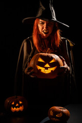 Wicked witch holding a jack-o-lantern for halloween
