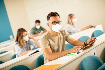 Male student wearing face protective medical mask for virus protection at lecture hall
