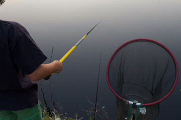 Un enfant pêche sur un étang