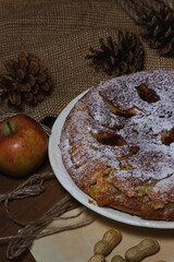 Homemade pie. Apple pie sprinkled with icing sugar. Pie on an autumn background. Autumn pastries