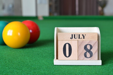 July 8, number cube with balls on snooker table, sport background.