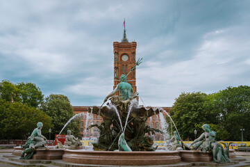 Neptunbrunnen mit Rotem Rathaus in Berlin an einem bewölkten Sommertag